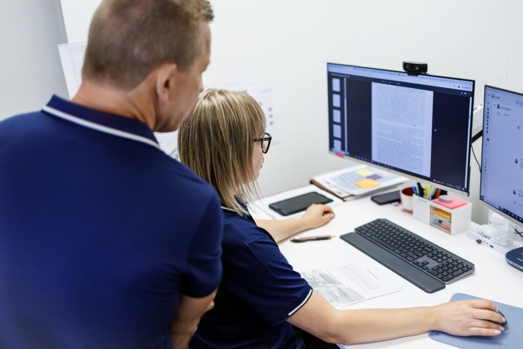two persons looking at pc screen