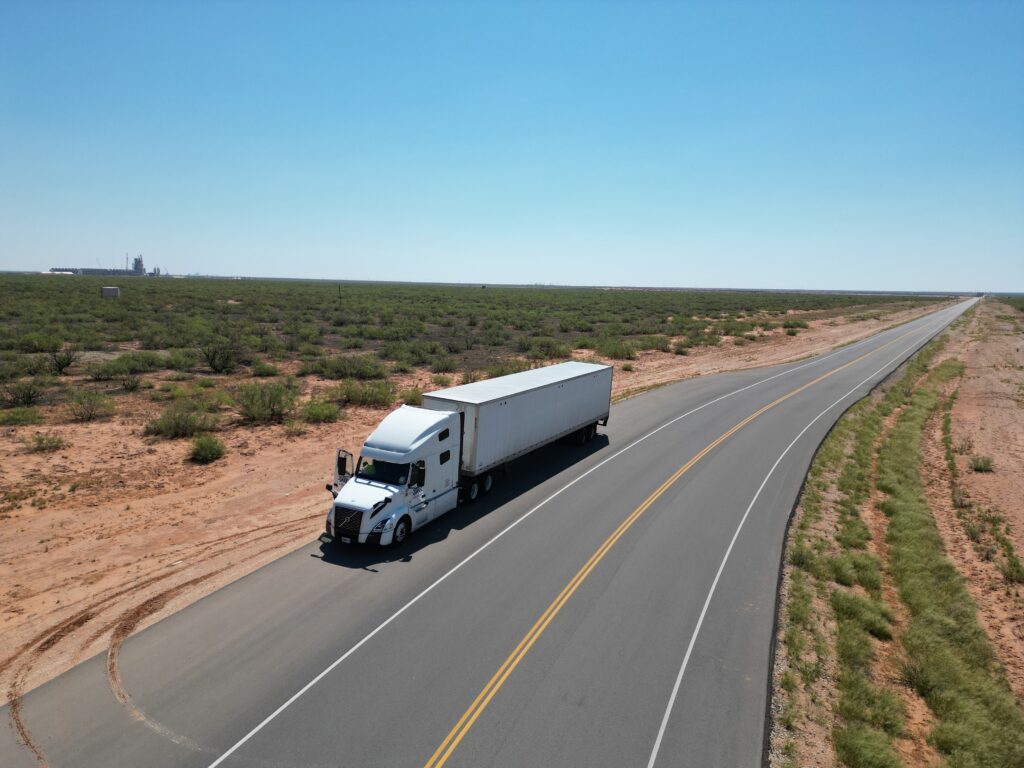 owner operator driving a truck in the desert
